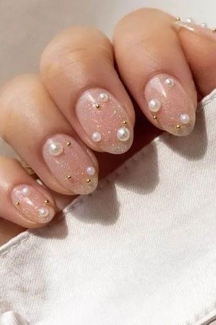 Gold dusted nude nails with pearl accents