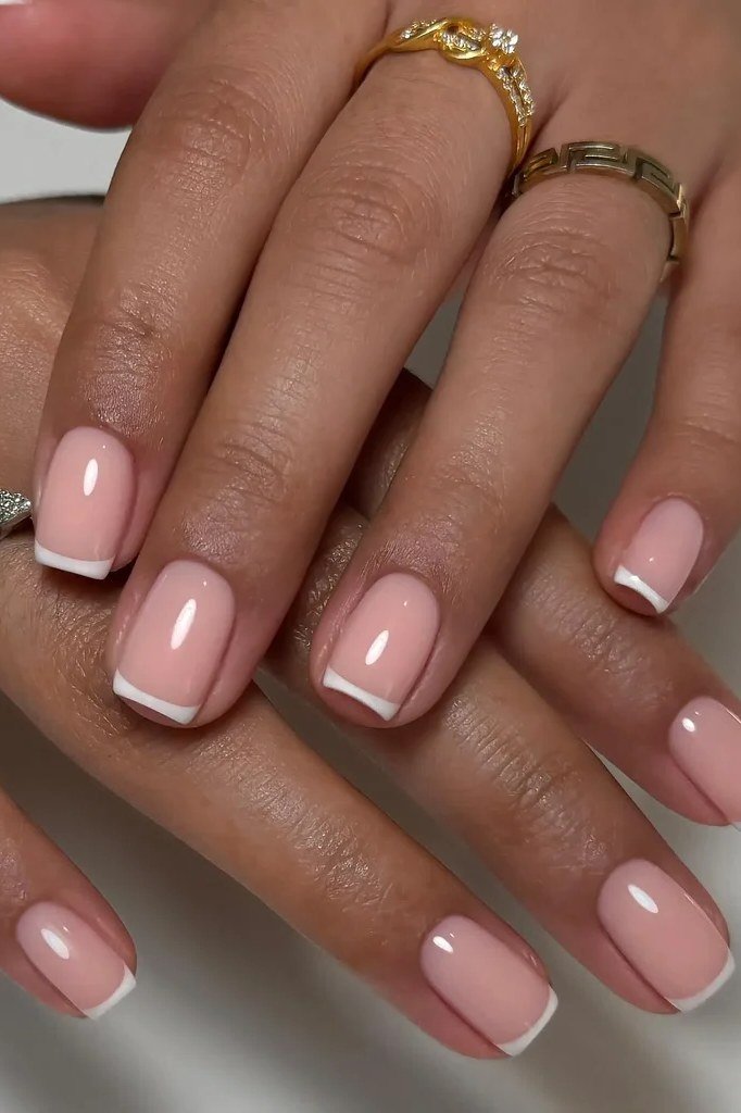 Pink french tips on hands with gold rings for women over 70