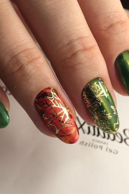 Forest green gel nails with gold and red leaf art, dramatic fall nail design
