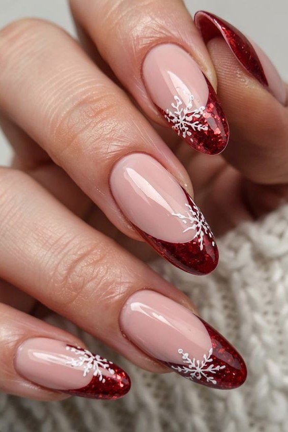 nude nails with red glitter french tips and snowflakes