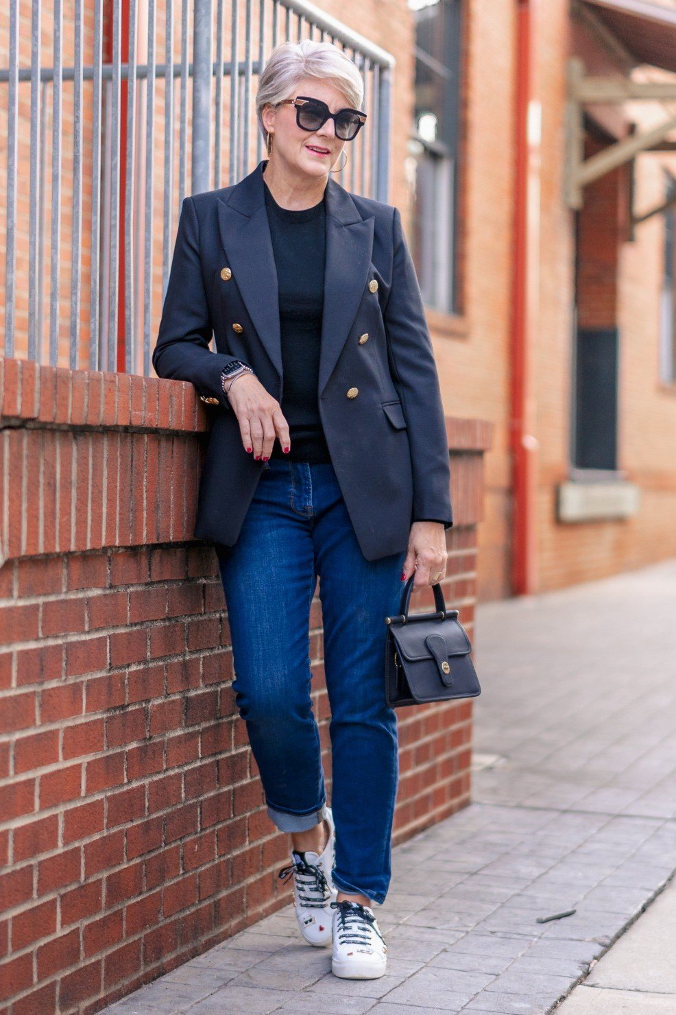 Navy double breasted blazer with jeans and sneakers for women over 60
