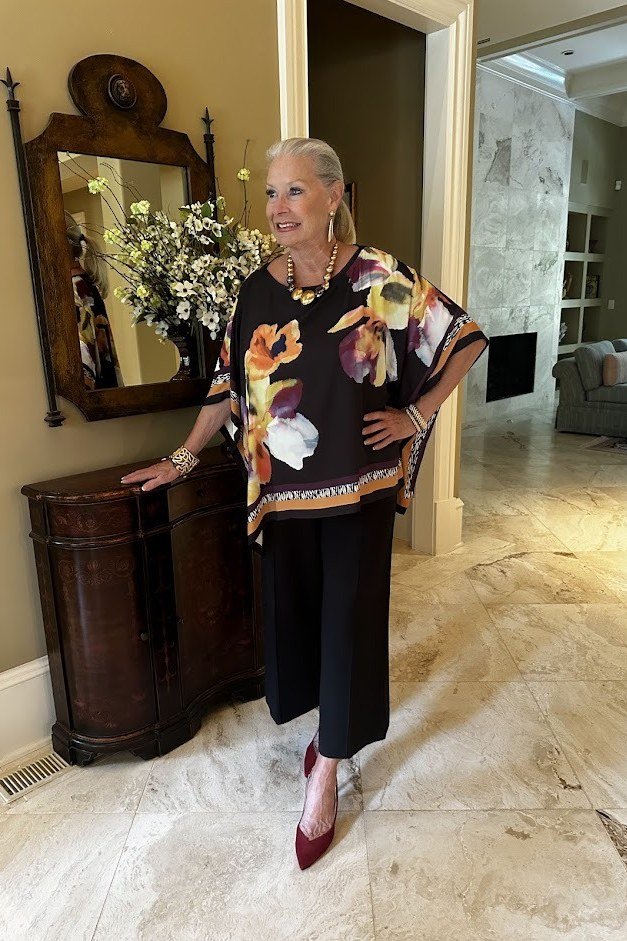 black orange floral poncho top black cropped trousers burgundy heels women over 50