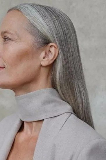 Long silver-gray straight hair with side sweep for women over 50