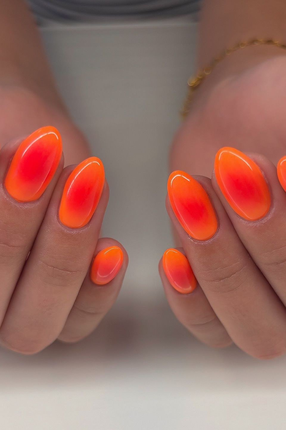 Neon Flame Orange Red Oval Ombre - Glowing orange bursts into hot red on these short oval nails with a juicy glossy finish.