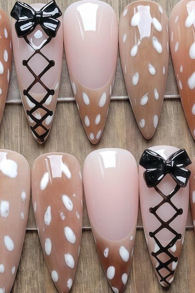 Nude press-on nail set with white spots and black corset lacing