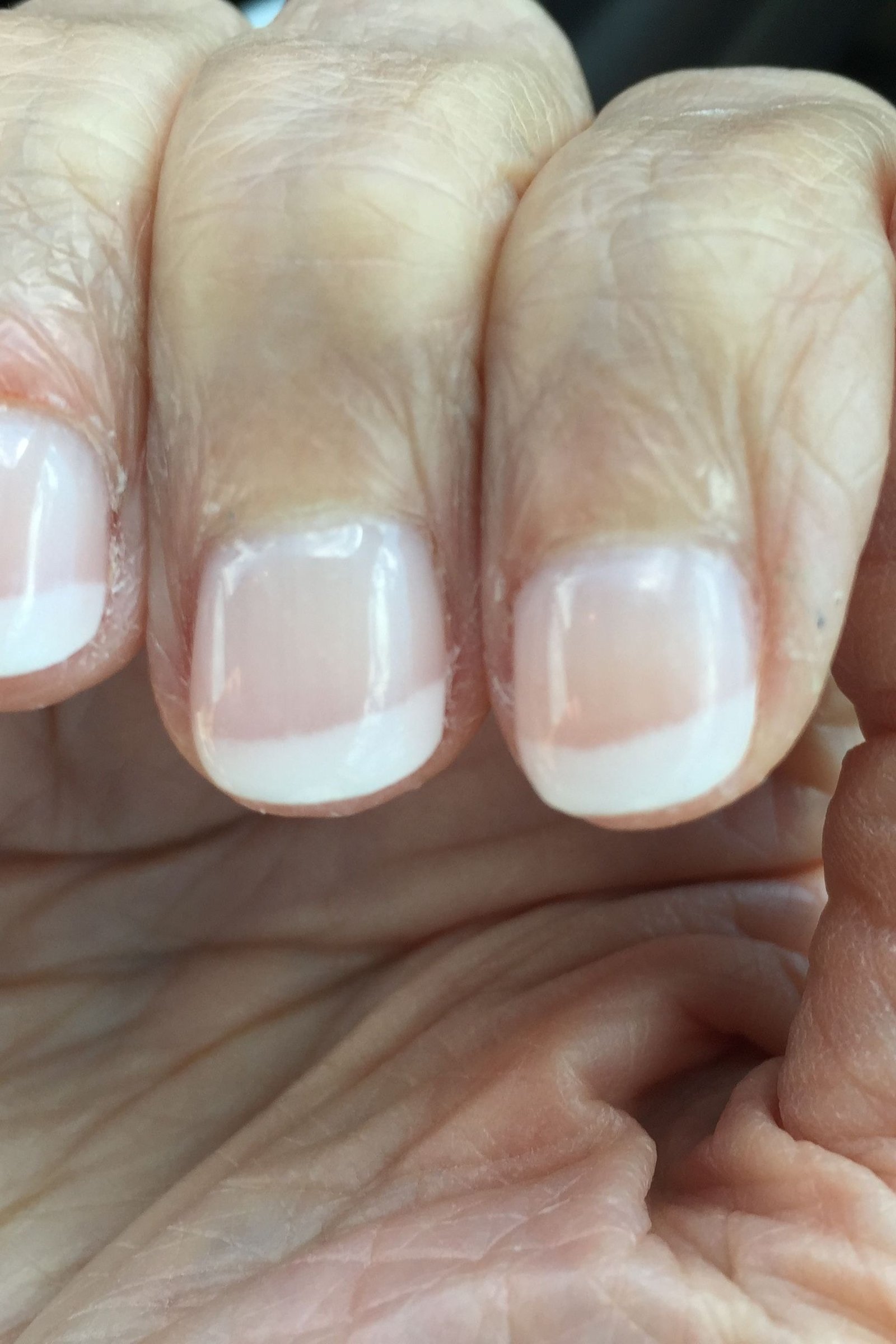 french tip nails close-up on aged hand