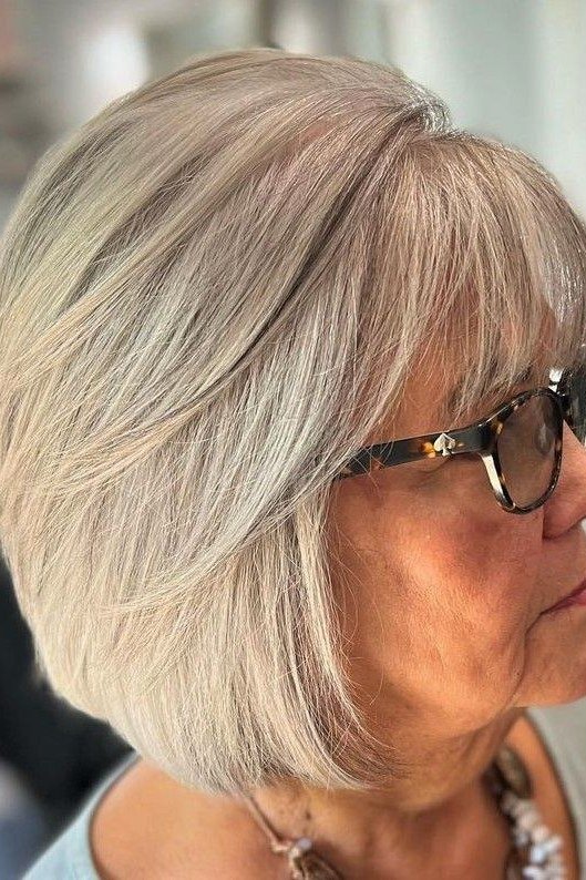 Sleek silver french bob with sunglasses in side profile