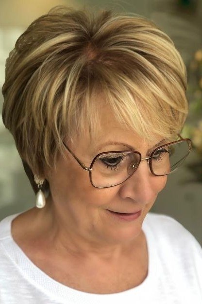Honey-blonde pixie haircut with glasses for women over 60