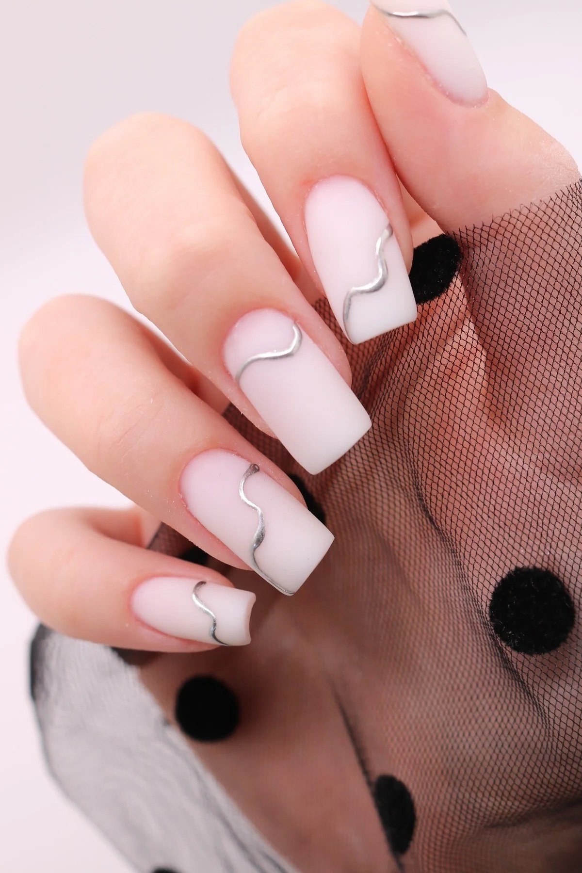Milky white nails with thin black swirl nail art