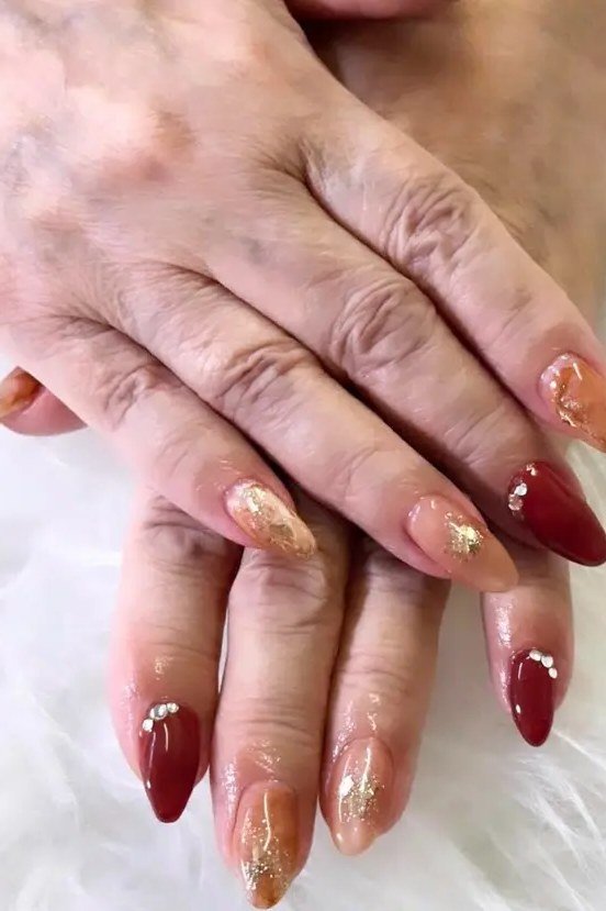 Red and gold glitter almond shaped nails manicure