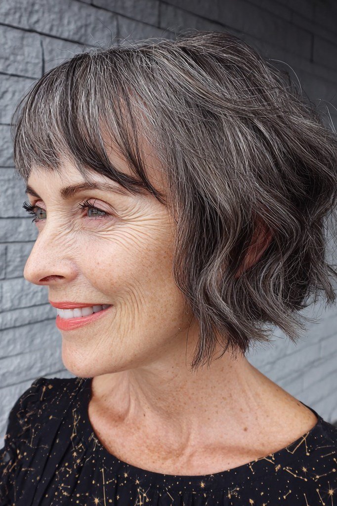 Wavy silver french bob with side fringe in side profile