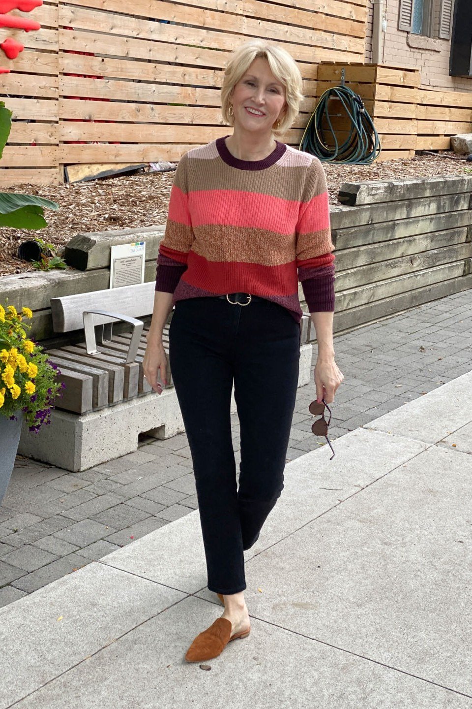 Red and pink striped sweater with black trousers and loafers