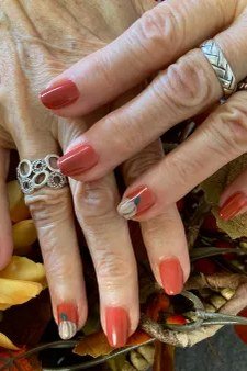 Terracotta nail polish with rings and fall flowers