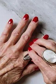 polished red nails on marble for older women