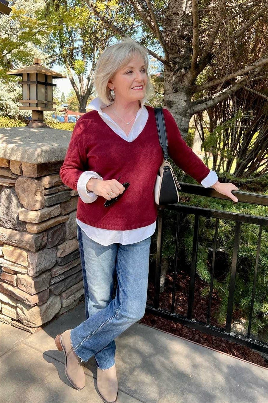 Casual fall outfit for women over 60: tan chelsea boots, black leggings, oatmeal tunic sweater