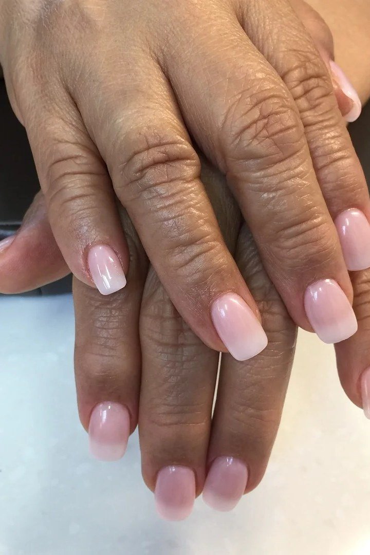 pink white baby boomer fade on short almond nails older hands