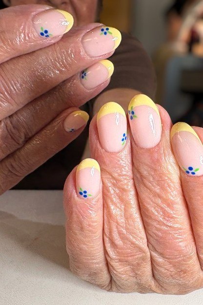 Yellow Tip Gel Nails with Blue Flowers - short gel nail idea for women over 50