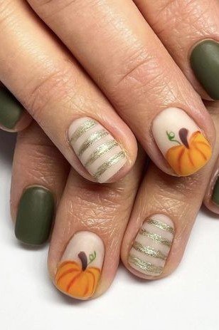 Olive green matte with hand-painted pumpkin art on nude accent nails, short oval, glossy, fall nail color for women over 40