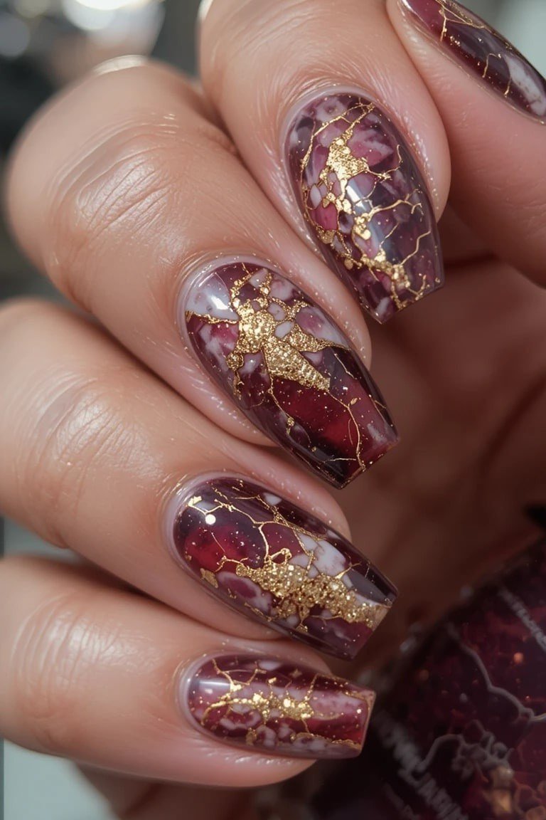 Burgundy gold foil marble almond nails for women over 50