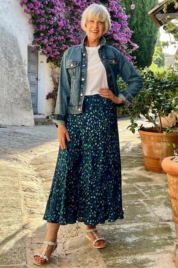 Easy casual outfit idea for women over 50: denim jacket over a floral maxi skirt, older woman everyday style