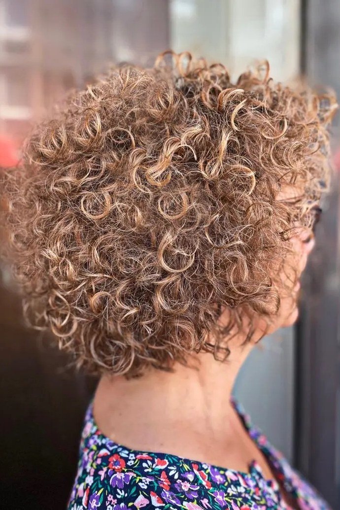 Salt-and-pepper curly bixie back and side view for women over 60