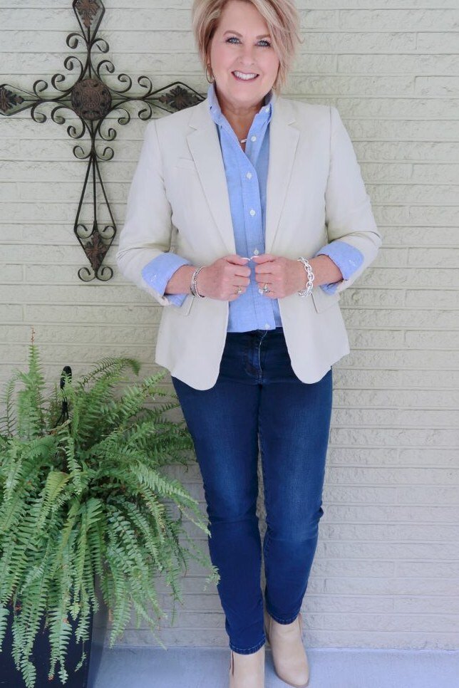 Woman over 50 wearing beige blazer with blue shirt and jeans, everyday casual outfit idea
