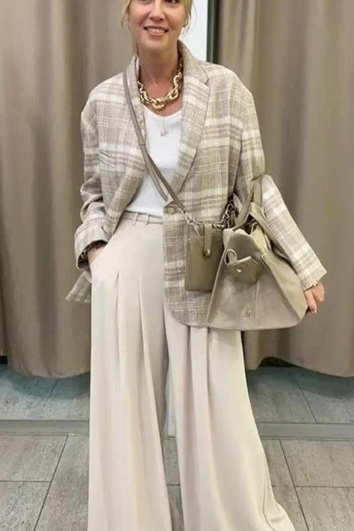 Beige plaid blazer over white top with white wide leg trousers, woman over 50
