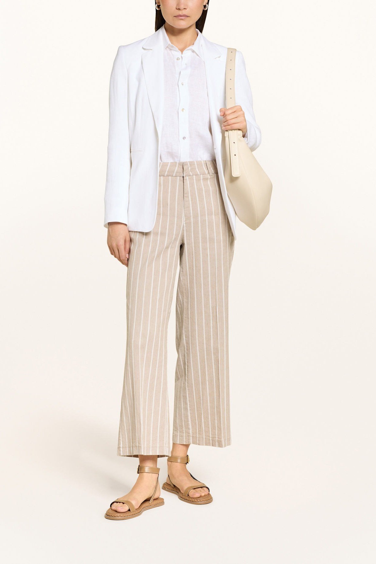 White blazer with striped wide-leg pants and shoulder bag, studio for women over 60