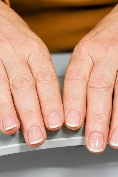 Nude short nails on elderly hands