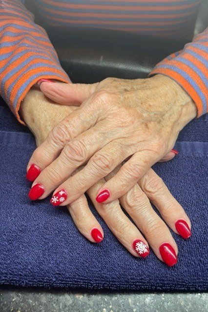 Red Nails With Snowflake Accent - winter nail trend for older women over 70