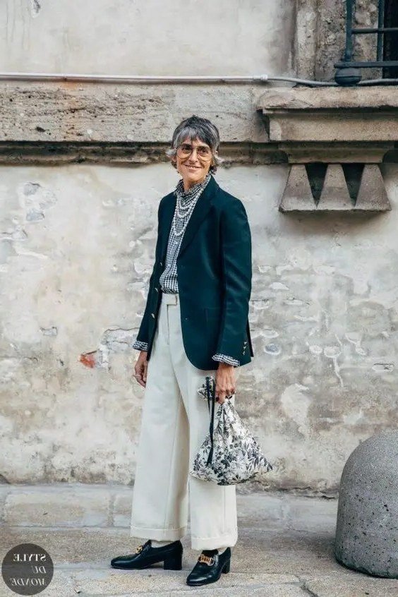 Teal blazer over striped top with white wide trousers, woman over 50