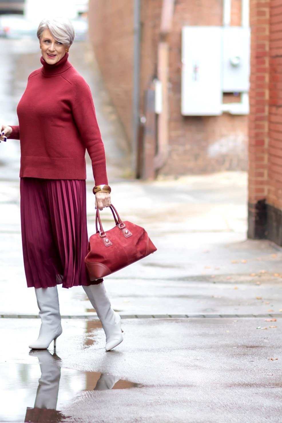 Easy casual outfit idea for women over 50: red turtleneck and burgundy pleated skirt, older woman everyday style