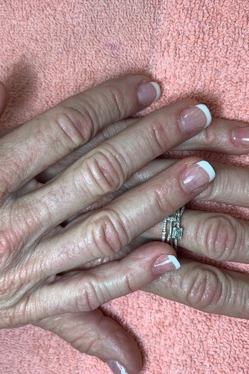 French tips in dusty blue grey on elderly hands