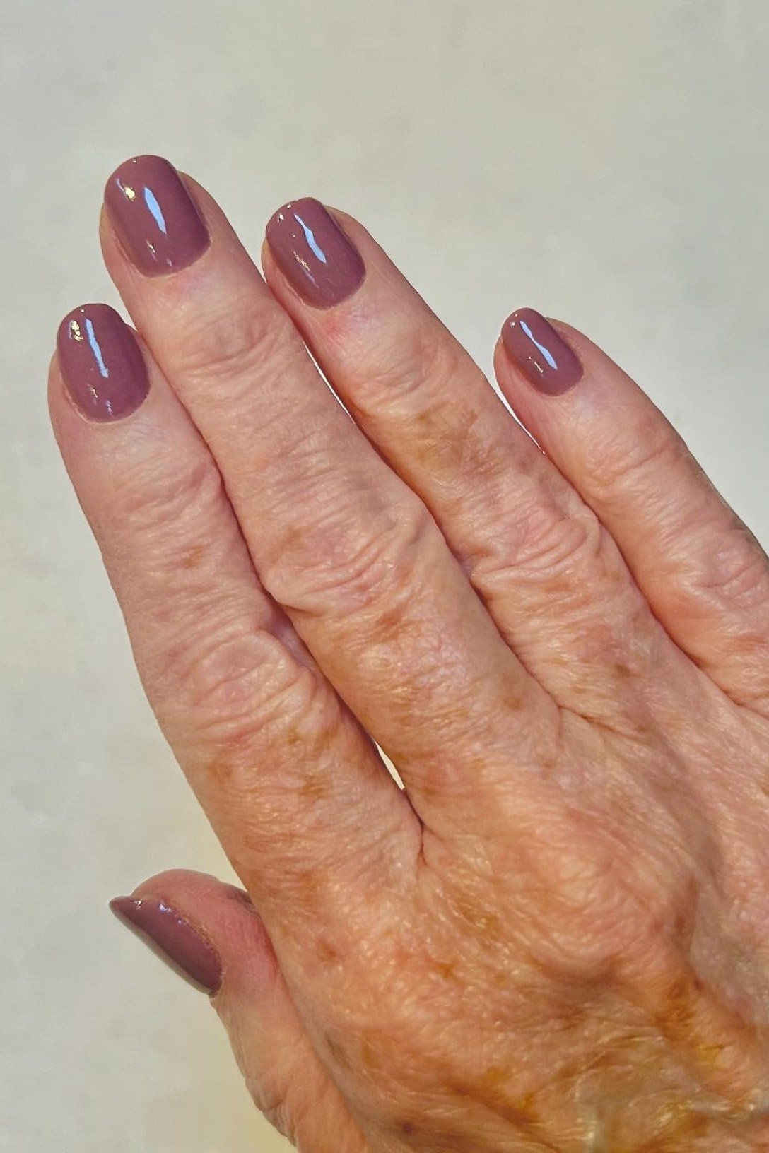 Muted Mauve Oval Nails on Older Hands - old money fall nail color for women over 40