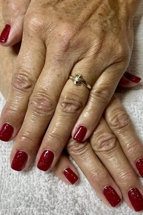 deep red on mature hands, white towel
