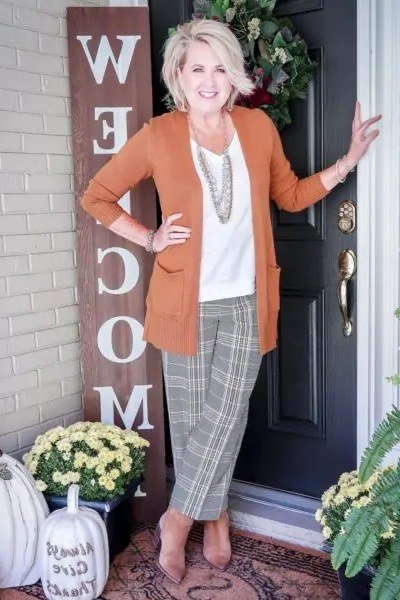 Rust blazer with a white top, grey plaid trousers, and layered necklaces, smart weekend outfit for women over 40