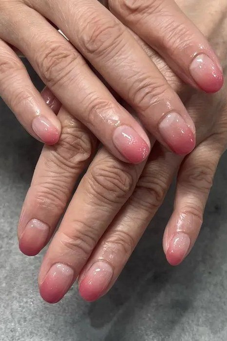 pink baby boomer fade on short almond nails older hands