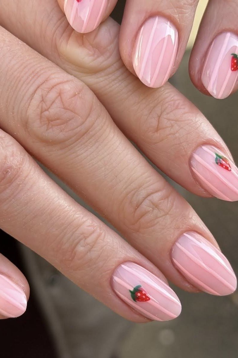 Sheer pink nails with tiny strawberry dot art