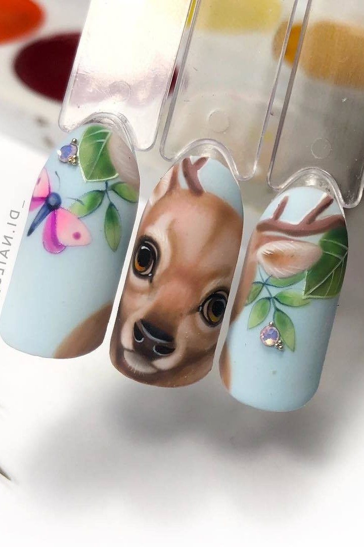 Nail art demo with hand-painted fawn face on blue background