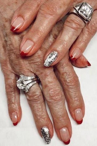 nude with red tips and silver glitter accent, ornate rings - winter nail trend for older women