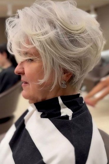 White feathered pixie, airy layers, salon side view for women over 60