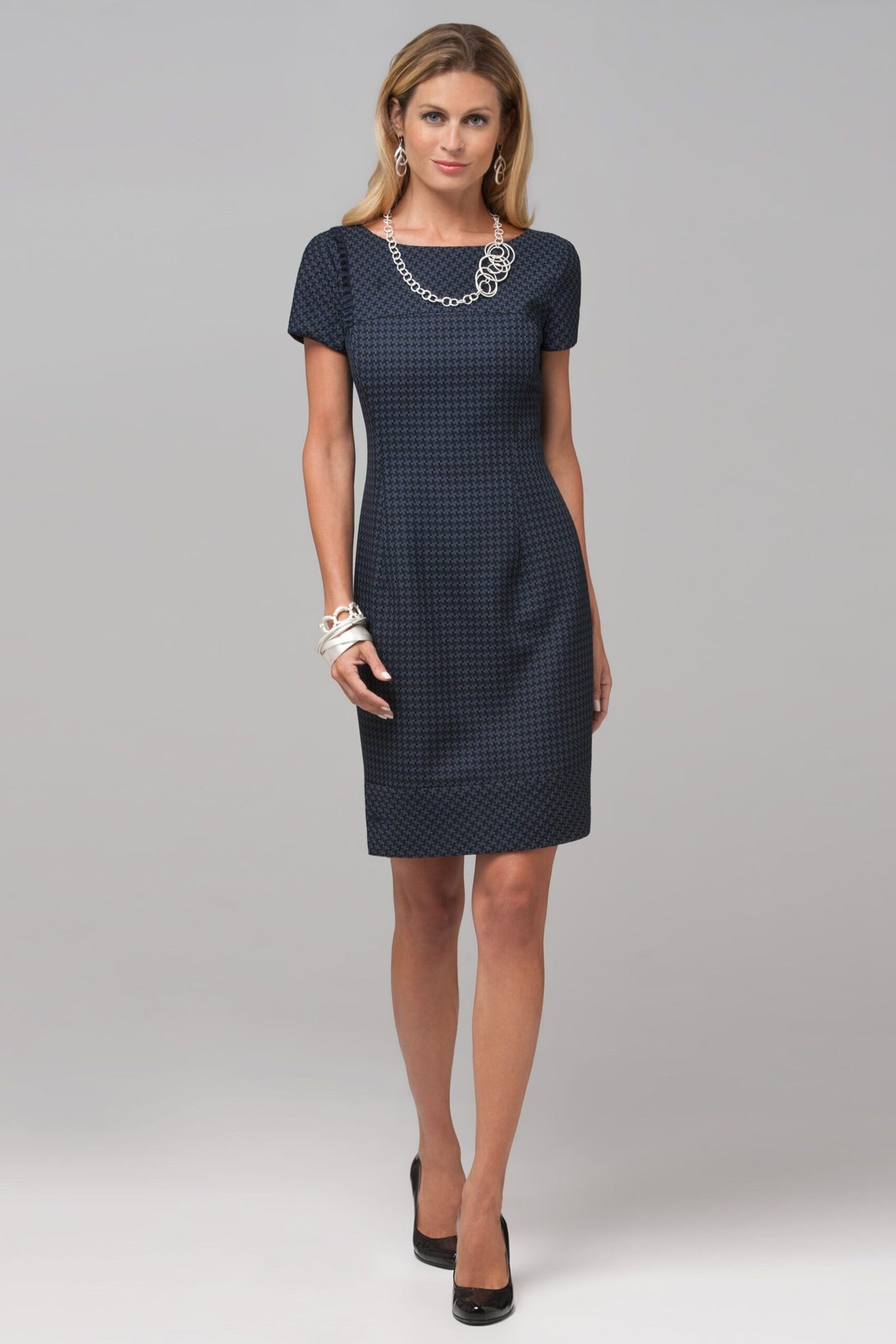 Navy sheath dress with necklace, blonde woman studio - business casual work outfit for women over 50