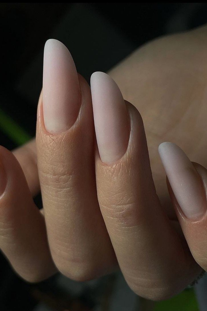 Matte nude almond nails on dark background