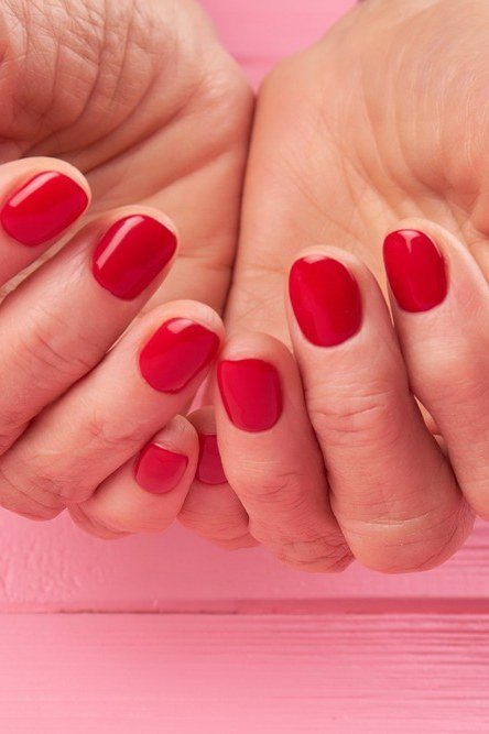 Red Cupped Hands on Pink gel nails for women over 60