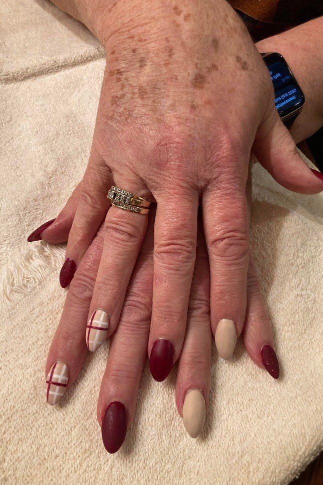 burgundy and nude on mature hands, gold ring