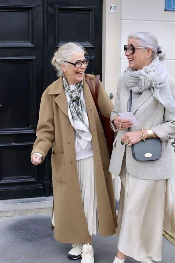 Effortlessly chic fall outfit for women over 60: two cream coats with scarves