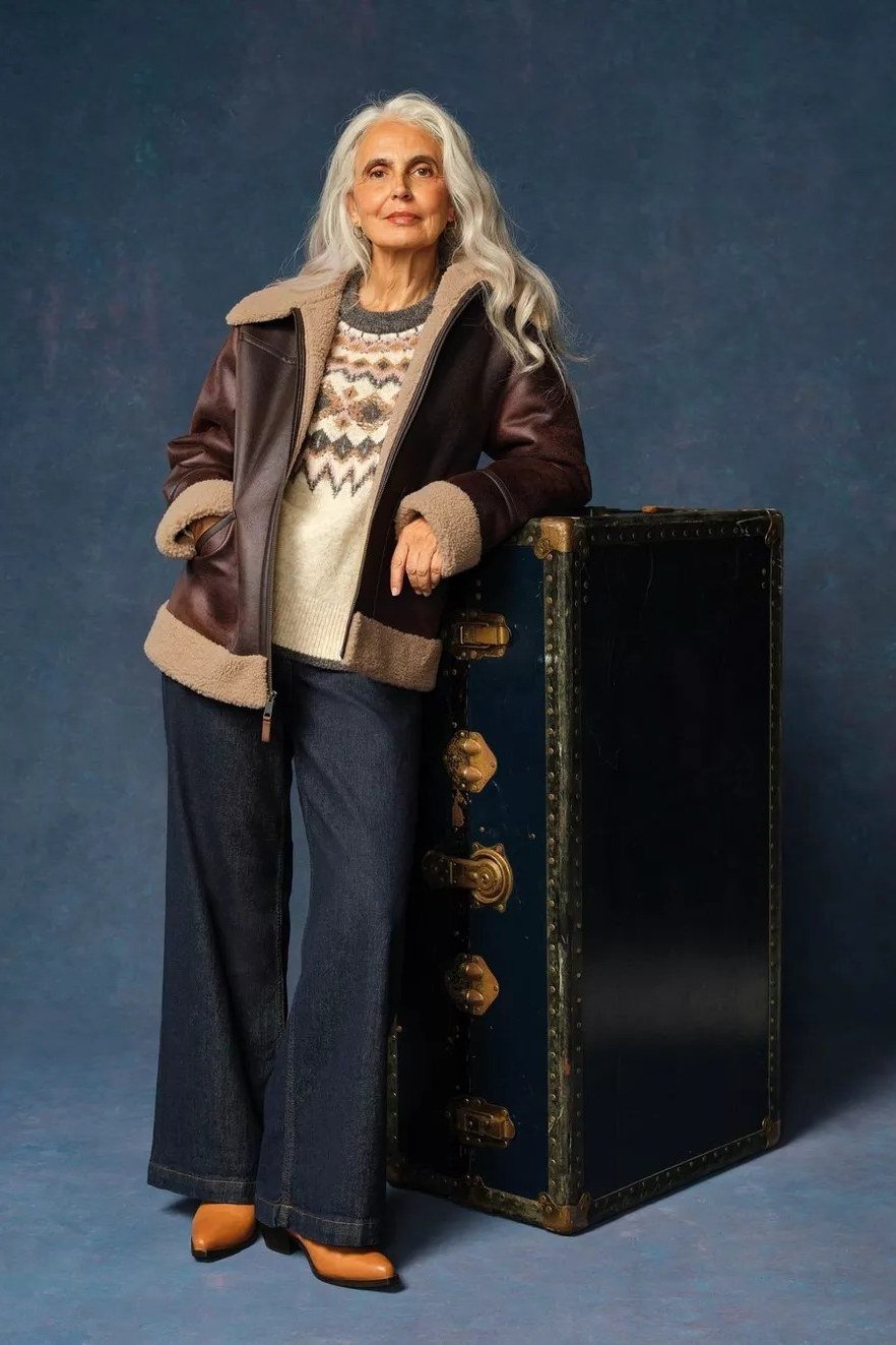 Brown shearling jacket over fair isle sweater with dark wide-leg trousers