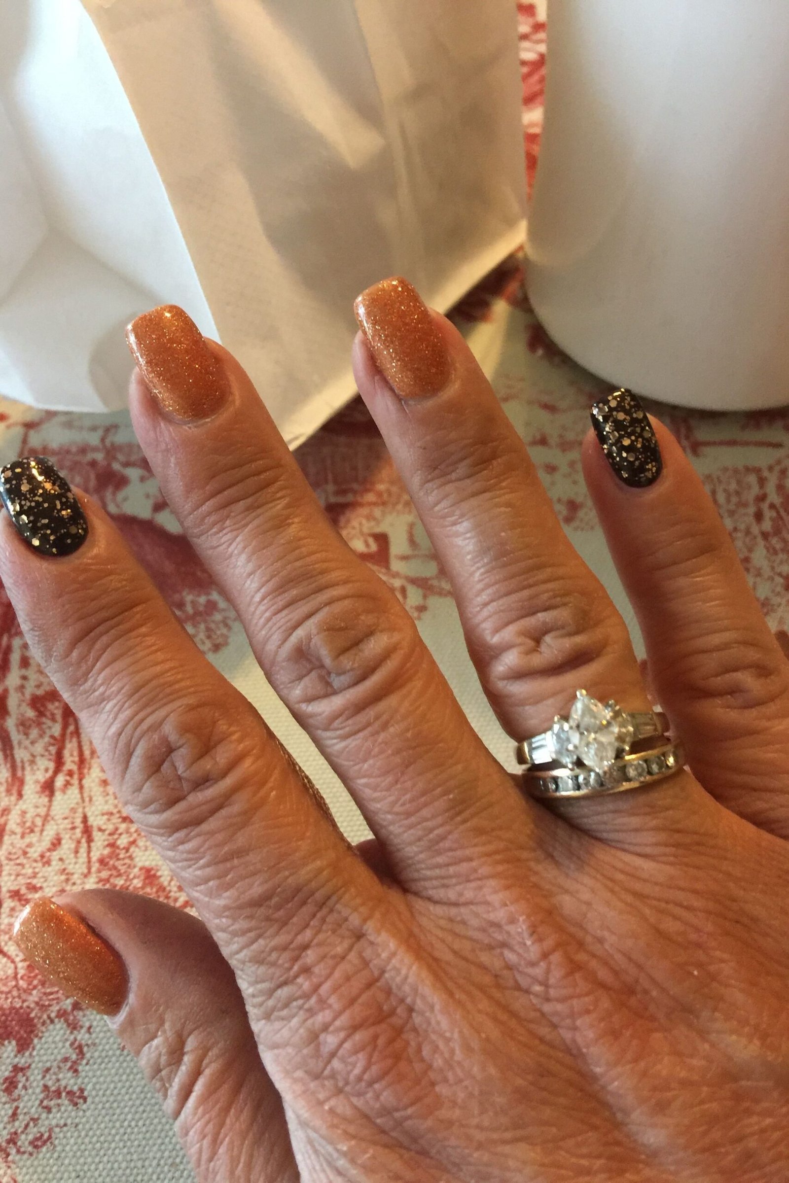 Rust tortoiseshell nails on mature hand, fall nail design for older women