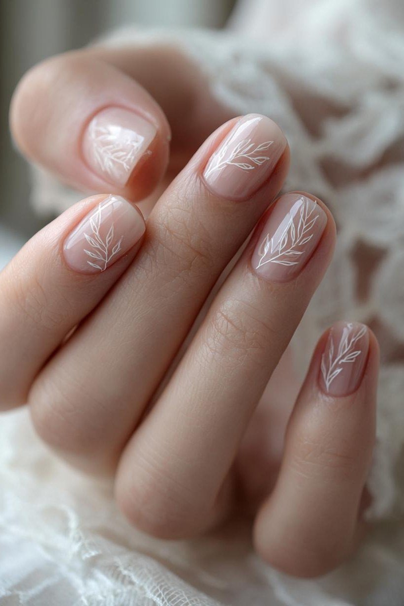 Delicate white floral nail art on nude, sophisticated nail design for women over 50
