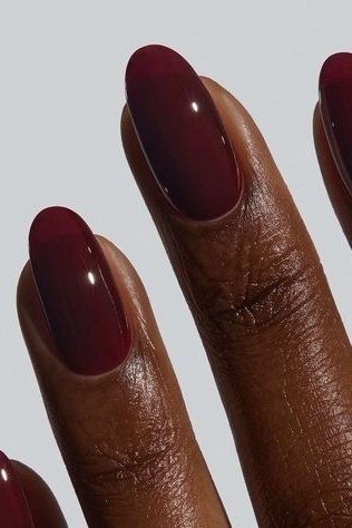 Glossy burgundy nails on deep skin tone for women over 50